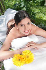 Image showing Beautiful young woman with flowers around
