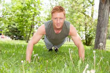 Image showing Man doing a push up in park