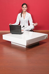 Image showing Beautiful businesswoman sitting in yoga lotus position