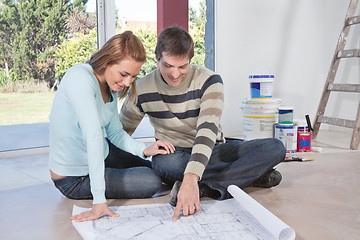 Image showing Man showing blueprint of their new house to his wife