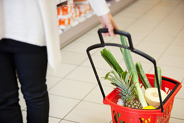 Image showing Woman pulling Shopping Basket in Grocery Store