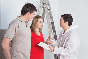 Image showing Workman suggesting colors to a mature couple