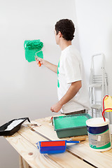 Image showing Casual man painting the wall of his new apartment