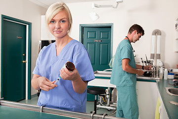 Image showing Nurse with syringe while doctor writing report