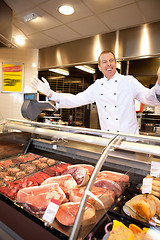 Image showing Fresh meat with cheerful butcher