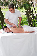 Image showing Man giving massage to woman by a wooden massager