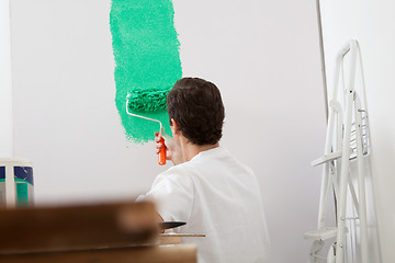 Image showing Man painting the wall with a roller