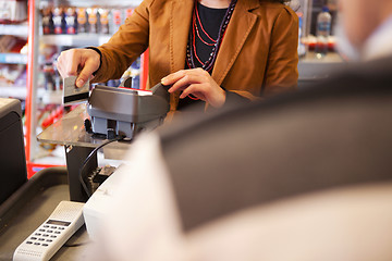 Image showing Shop assistant swiping credit card