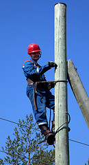 Image showing Electrician on a pole makes installation work