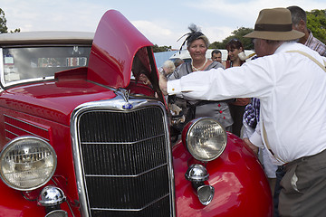 Image showing People looking at an old automobile.