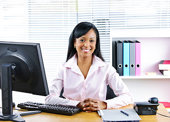 Image showing Smiling black businesswoman at desk