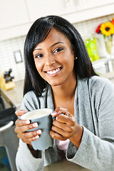 Image showing Woman in kitchen with coffee cup