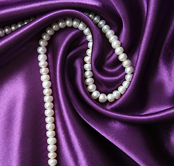 Image showing White pearls on a lilac silk background 