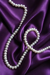 Image showing White pearls on a lilac silk background 