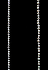 Image showing White pearls on the black silk 