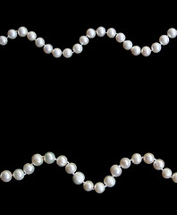 Image showing White pearls on the black silk 