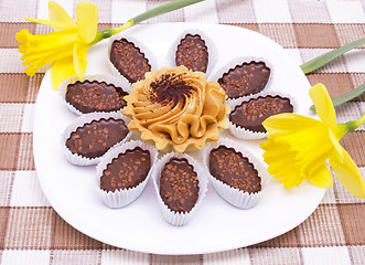 Image showing Cake and chocolates on the white plate with two daffodils