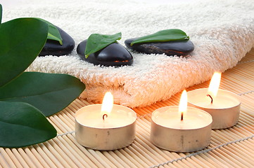 Image showing foldet white bath towel and zen stones