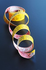 Image showing measuring tape on blue background