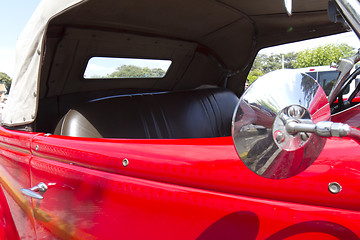 Image showing Close up detail of a red classic car .