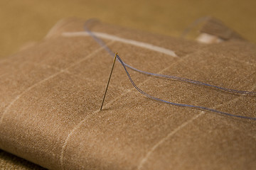 Image showing needle and thread on fabric background