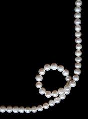 Image showing White pearls on the black silk as background 