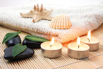 Image showing foldet white bath towel and zen stones