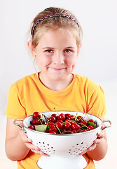 Image showing Child holding a bowl of fresh cherries