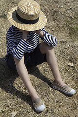 Image showing Sulky boy sitting down.