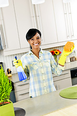 Image showing Young woman cleaning kitchen