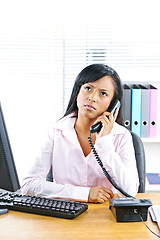 Image showing Concerned black businesswoman on phone at desk