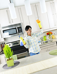 Image showing Young woman cleaning kitchen