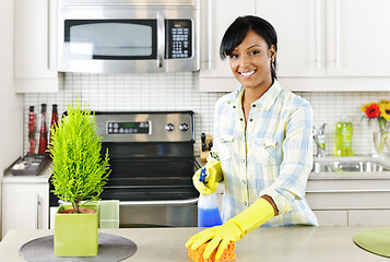 Image showing Young woman cleaning kitchen