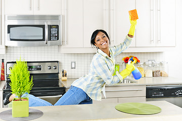 Image showing Young woman cleaning kitchen