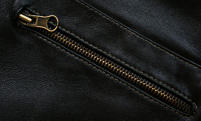 Image showing Zipper on the black leather texture as background