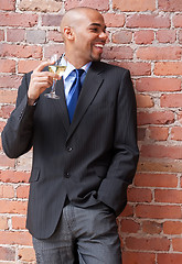 Image showing Laughing young businessman with a glass of wine