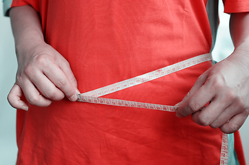 Image showing Fat woman measuring waist