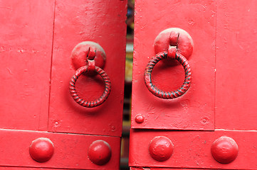 Image showing Red door with iron doorknobs