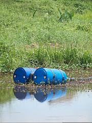 Image showing Blue toxic drums in river