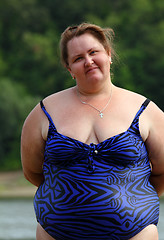 Image showing plump woman standing near river