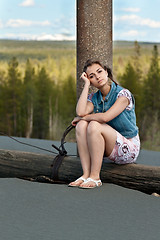 Image showing sad girl sitting on a log