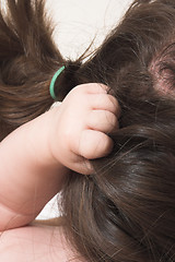 Image showing baby grabbing hair