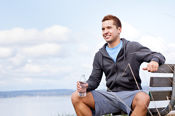 Image showing Mixed race man holding water bottle