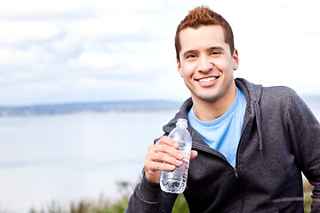 Image showing Mixed race man holding water bottle