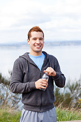 Image showing Mixed race man holding water bottle