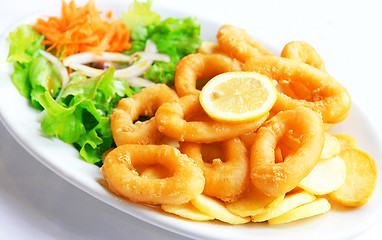 Image showing Deep batter fried squid rings calamari with green salad 