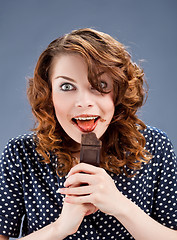 Image showing happy smiling woman eating chocolate