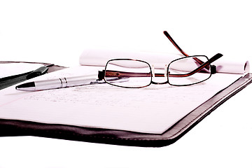 Image showing sunglasses and pen place on note book isolate on white background 