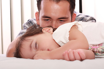 Image showing Father watch his beautiful baby while she sleeps