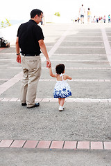 Image showing Baby walking like a model with her father